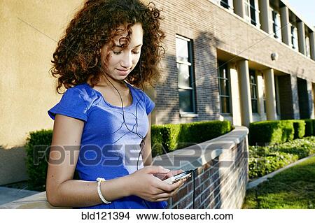 Mixed race student listening to headphones View Large Photo Image Picture - Mixed race student listening to headphones. Fotosearch
