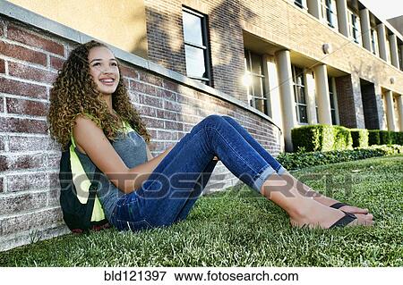 Mixed race student sitting on grass View Large Photo Image Stock Photo - Mixed race student sitting on grass. Fotosearch