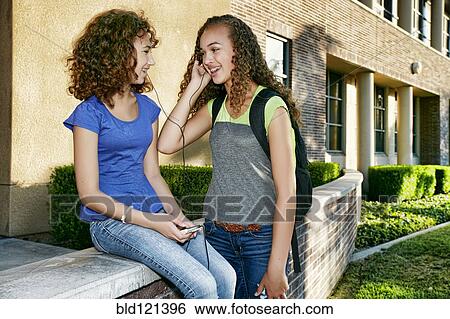 Mixed race students listening to headphones View Large Photo Image Stock Photograph - Mixed race students listening to headphones. Fotosearch