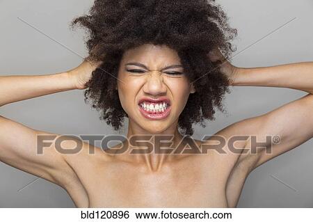 Stock Photograph - Mixed race woman grimacing. Fotosearch