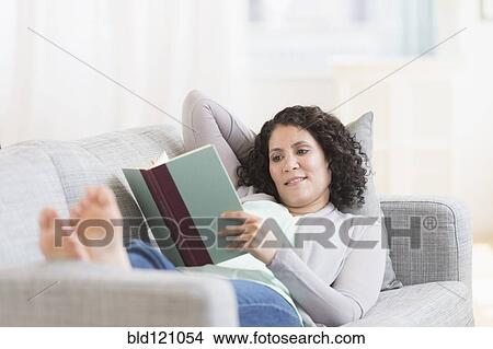 Mixed race woman reading on sofa View Large Photo Image Picture - Mixed race woman reading on sofa. Fotosearch