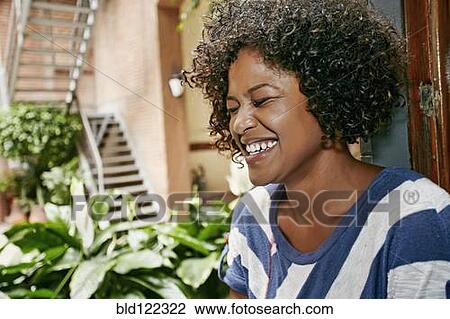 Stock Image - Mixed race woman sitting in window. Fotosearch