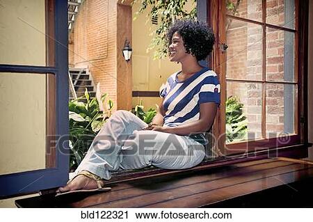 Mixed race woman sitting in windowsill View Large Photo Image Stock Image - Mixed race woman sitting in windowsill. Fotosearch