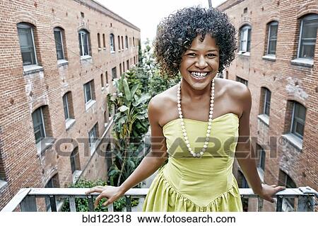 Stock Photo - Mixed race woman smiling on balcony. Fotosearch