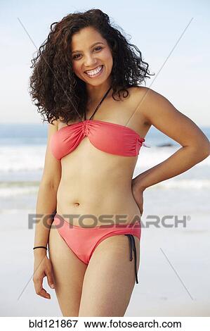 Stock Photo - Mixed race woman smiling on beach. Fotosearch