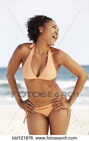 Stock Photograph - Mixed race woman smiling on beach. Fotosearch