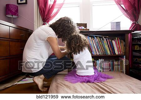 Mother and daughter picking books from shelf View Large Photo Image Stock Photo - Mother and daughter picking books from shelf. Fotosearch