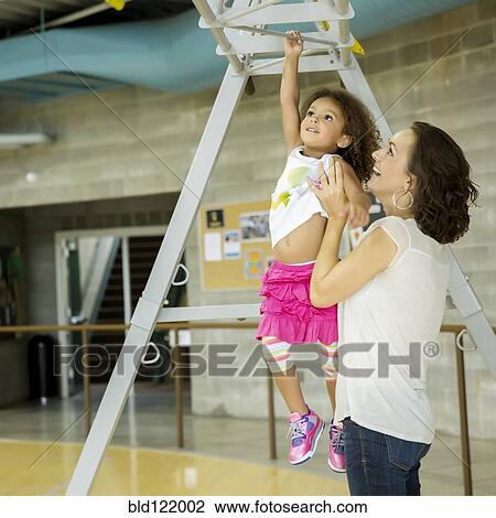 Stock Image - Mother and daughter playing in gym. Fotosearch