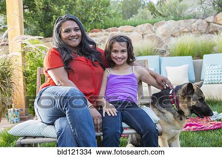 Picture - Mother and daughter relaxing in backyard. Fotosearch