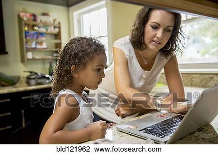 Mother and daughter using laptop in kitchen View Large Photo Image Stock Image - Mother and daughter using laptop in kitchen. Fotosearch
