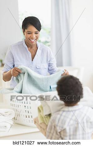 Stock Photo - Mother and son folding laundry. Fotosearch