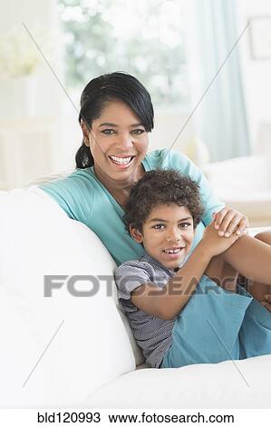 Mother and son relaxing on sofa View Large Photo Image Stock Image - Mother and son relaxing on sofa. Fotosearch