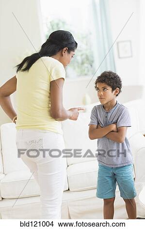 Mother scolding son in living room View Large Photo Image Picture - Mother scolding son in living room. Fotosearch