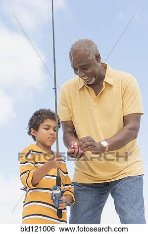 Stock Photograph - Older man teaching grandson to fish. Fotosearch