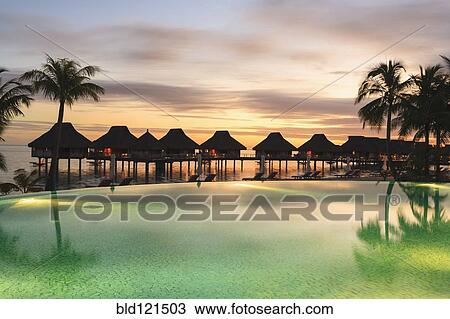 Stock Image - Palm trees and tropical resort, Bora Bora, French Polynesia. Fotosearch