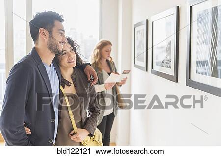 Stock Image - People admiring art in gallery. Fotosearch