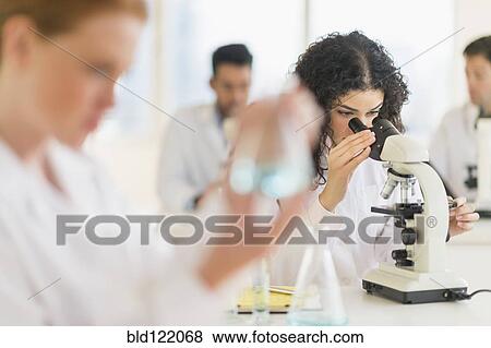 Stock Photo - Scientist using microscope in laboratory. Fotosearch