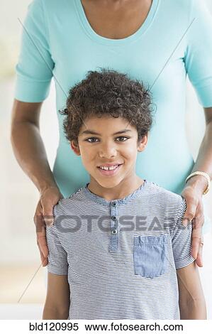 Smiling boy standing with mother View Large Photo Image Stock Photography - Smiling boy standing with mother. Fotosearch