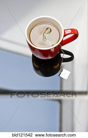 Stock Image - Tea steeping in mug on glass table. Fotosearch