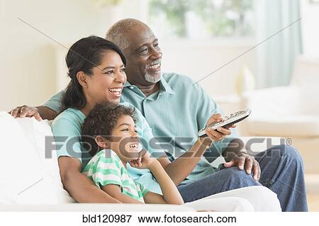 Stock Photo - Three generations of family watching tv. Fotosearch