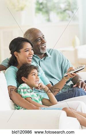 Stock Photograph - Three generations of family watching tv. Fotosearch