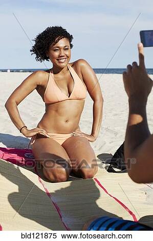 Stock Photography - Woman posing for photograph on beach. Fotosearch
