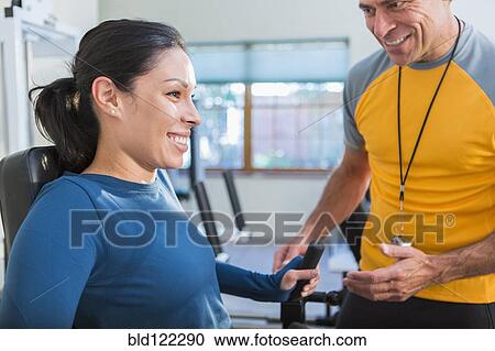 Woman working with personal trainer in gym View Large Photo Image Stock Image - Woman working with personal trainer in gym. Fotosearch