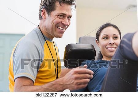 Woman working with personal trainer in gym View Large Photo Image Stock Photo - Woman working with personal trainer in gym. Fotosearch