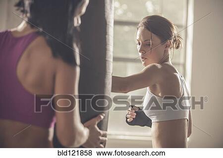 Stock Photo - Woman working with trainer in gym. Fotosearch