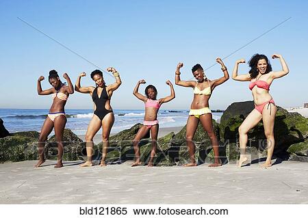 Women flexing muscles on beach View Large Photo Image Stock Photography - Women flexing muscles on beach. Fotosearch