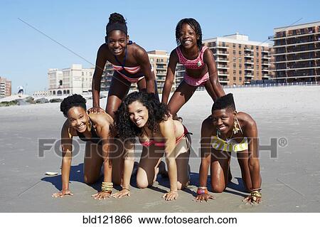 Women forming pyramid on beach View Large Photo Image Stock Photograph - Women forming pyramid on beach. Fotosearch