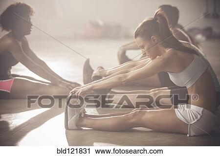 Stock Image - Women stretching in gym. Fotosearch