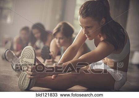 Stock Image - Women stretching in gym. Fotosearch