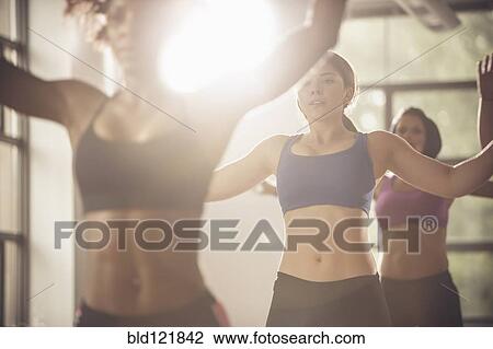 Stock Image - Women working out in exercise class. Fotosearch