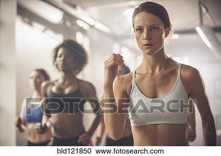 Stock Image - Women working out in exercise class. Fotosearch
