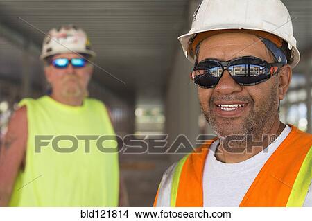 Workers smiling at construction site View Large Photo Image Picture - Workers smiling at construction site. Fotosearch