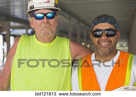 Workers smiling at construction site View Large Photo Image Stock Image - Workers smiling at construction site. Fotosearch