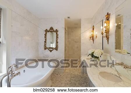 Stock Photo - Bathtub and mirrors in ornate bathroom. Fotosearch