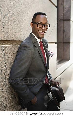 Stock Photograph - Black businessman smiling on city street. Fotosearch
