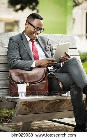 Black businessman using digital tablet outdoors View Large Photo Image Stock Photo - Black businessman using digital tablet outdoors. Fotosearch