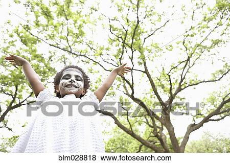 Stock Photo - Black girl wearing face paint outdoors. Fotosearch