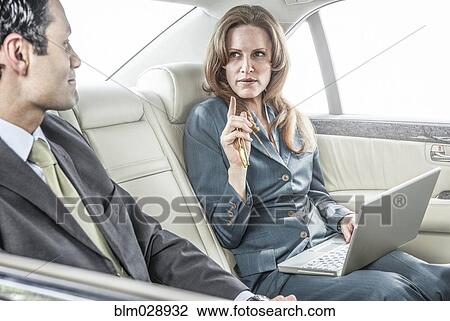 Business people working in backseat of car View Large Photo Image Stock Image - Business people working in backseat of car. Fotosearch