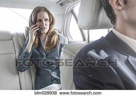 Stock Photo - Businesswoman talking on cell phone in car. Fotosearch