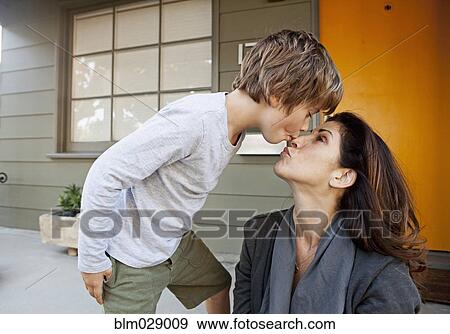 Stock Photo - Caucasian boy kissing mother on patio. Fotosearch