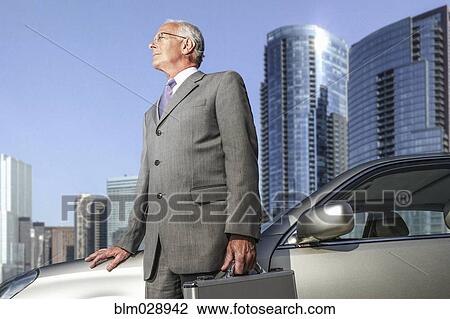 Caucasian businessman standing by city skyline View Large Photo Image Stock Image - Caucasian businessman standing by city skyline. Fotosearch