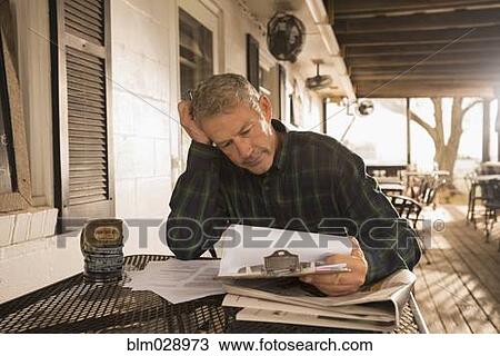 Stock Image - Caucasian businessman working on patio. Fotosearch