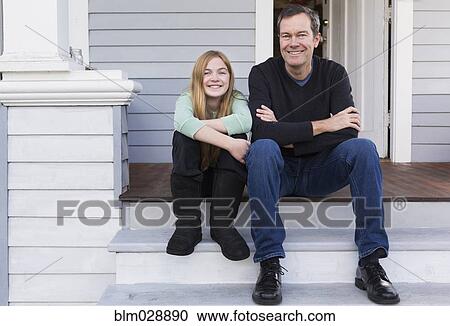 Stock Image - Caucasian father and daughter smiling on steps. Fotosearch