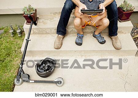 Caucasian father and son using digital tablet outdoors View Large Photo Image Stock Image - Caucasian father and son using digital tablet outdoors. Fotosearch
