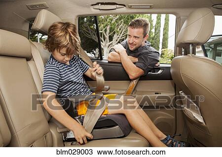 Caucasian father fastening son into car seat View Large Photo Image Stock Image - Caucasian father fastening son into car seat. Fotosearch