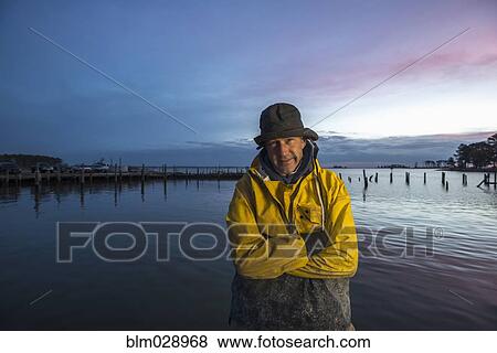 Caucasian fisherman standing by ocean View Large Photo Image Stock Photo - Caucasian fisherman standing by ocean. Fotosearch